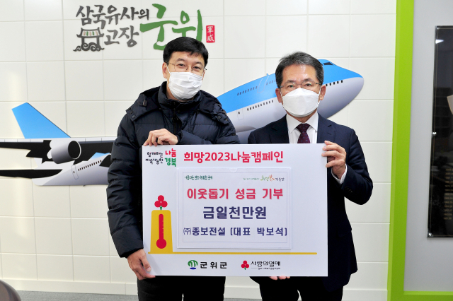 박보석(왼쪽) ㈜종보전설 대표가 김진열 군위군수에게 이웃돕기 성금 1천만원을 기탁하고 기념 사진을 촬영하고 있다. 군위군 제공