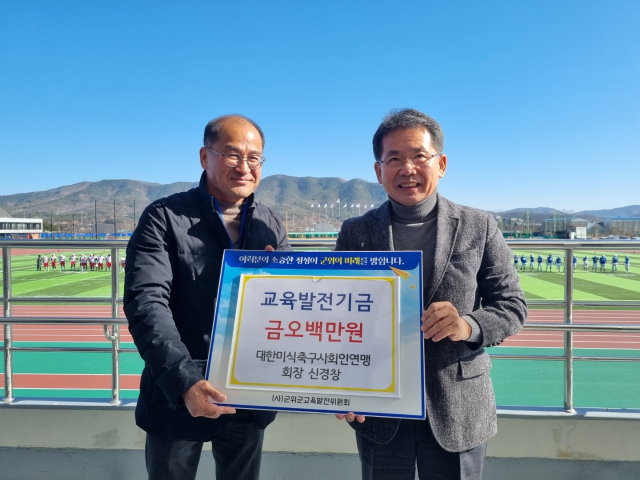 신경창(왼쪽) 대한미식축구 사회인연맹 회장이 김진열 군위군수에게 교육발전기금 500만원을 기탁하고, 기념 사진을 촬영하고 있다. 군위군 제공