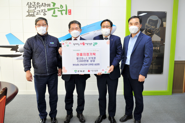 송강호(왼쪽 두번째) NH농협은행 군위군 지부장이 쌀을 기탁한 뒤 김진열(오른쪽 두번째) 경북 군위군수와 기념 사진을 찍고 있다. 군위군 제공