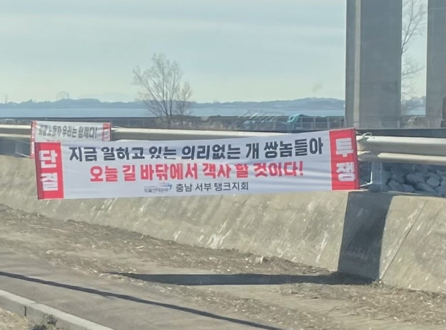 파업에 참여하지 않은 비조합원의 트레일러 차량에 쇠구슬을 발사한 화물연대가 이번에는 비조합원을 향해 비속어를 섞은 악담을 플래카드로 내걸어 논란이 일고 있다. 온라인 커뮤니티 갈무리