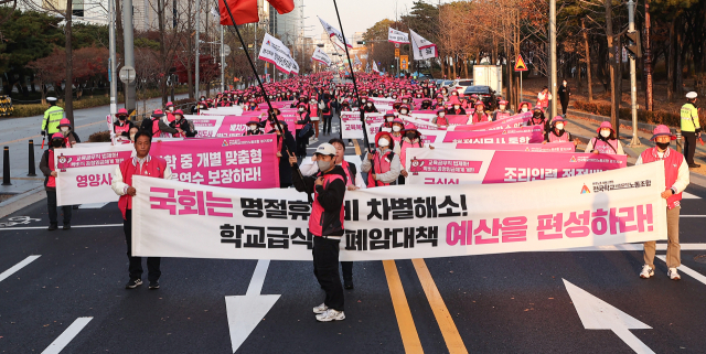전국학교비정규직노동조합 조합원들이 서울 영등포구 여의대로에서 국회로 행진하고 있다. 이들은 정규직과의 임금 차별 해소와 급식실 폐암 종합대책 마련, 교육교부금 축소 반대 등을 주장했다. 연합뉴스