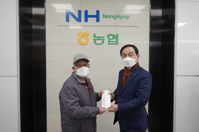 김영태(오른쪽) 구미농협 조합장이 구미지역 소외계층에게 임직원들이 모은 1천100만원의 성금을 기부하고 있다. 구미농협 제공