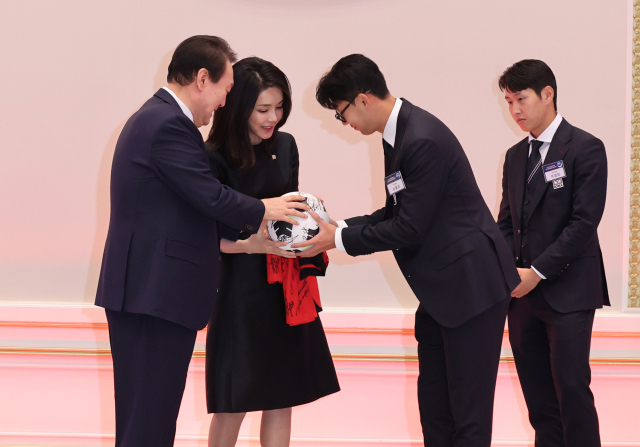 8일 청와대 영빈관에서 열린 축구 국가대표팀 환영 만찬에서 손흥민 선수와 이강인 선수가 윤석열 대통령과 김건희 여사에게 직접 사인한 축구공과 유니폼을 선물하고 있다. 연합뉴스