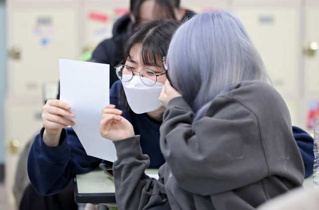 2023학년도 대학수학능력시험 성적표가 배부된 지난해 12월 9일 대구 중구 경북여자고등학교에서 고3 수험생들이 자신의 수능 점수를 확인하고 있다. 김영진 기자 kyjmaeil@imaeil.com