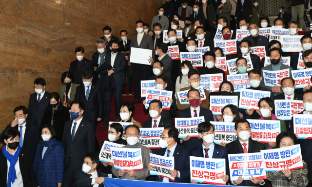 국민의힘 의원들이 11일 국회 로텐더홀 계단에서 이상민 행정안전부 장관 해임 건의안 강행 처리를 규탄하는 피켓을 들고 있는 가운데 본회의 표결을 마친 더불어민주당 의원들이 계단을 내려오고 있다. 연합뉴스