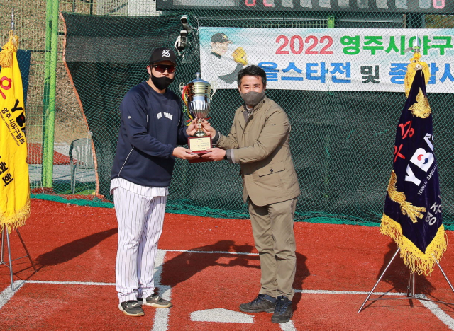 황병성 영주시야구협회장이 1부리그 우승팀 조현민 감독에게 트로피를 전달하고 있다. 영주시 제공