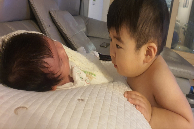 김윤정·서재득 부부의 첫째 아들 정민(2)이가 얼마전 태어난 여동생 유나를 신기한 듯 바라보고 있다..