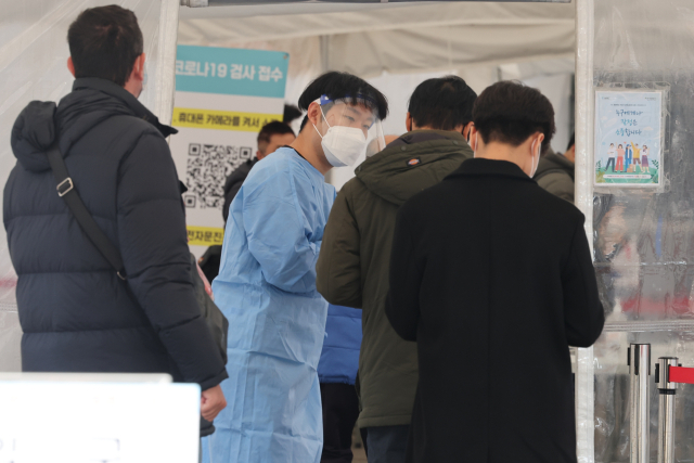 코로나19 신규 확진자가 늘어나는 가운데 12일 오후 서울 중구 서울역 임시 선별검사소에서 시민들이 검사를 받기 위해 순서를 기다리고 있다. 연합뉴스