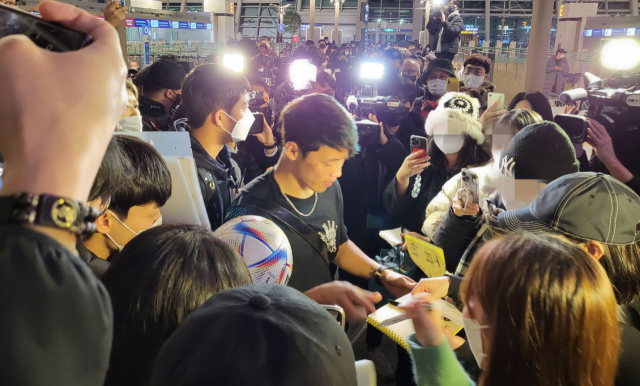 2022 국제축구연맹(FIFA) 카타르 월드컵에서 한국의 16강 진출에 기여한 공격수 황희찬이 소속팀인 울버햄프턴으로 복귀하기 위해 10일 오후 인천국제공항을 통해 출국하며 팬들에게 사인을 해주고 있다. 연합뉴스
