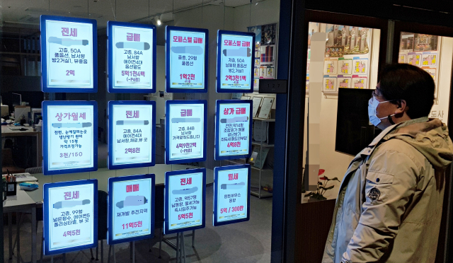 지난 연말 대구 중구 한 부동산 중개업소 앞에서 매물 안내문을 살피고 있는 시민 모습. 채정민 기자