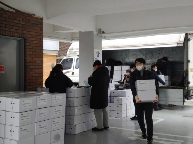 옥수동 인근 소외계층에 전달할 김치를 나르고 있는 봉사자와 관계자들