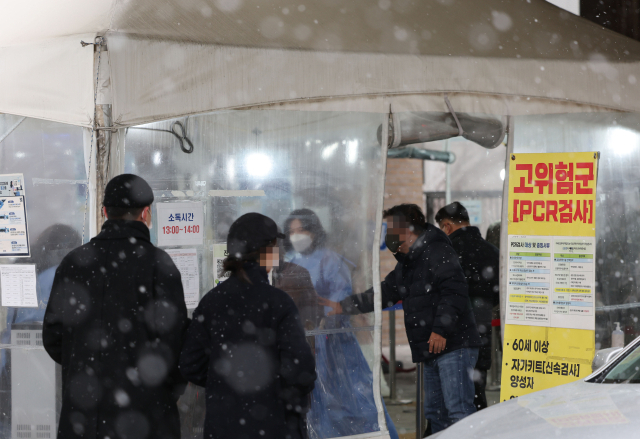 전국이 대체로 흐리고 눈이 내리는 13일 오후 서울 마포구보건소 코로나19 선별진료소에서 검사를 받으려는 시민들이 이동하고 있다. 연합뉴스