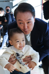 윤석열 대통령이 지난 12월 17일 서울 서초동 아크로비스타 사저를 찾아 주민들에게 감사 인사를 전한 뒤 한 어린이와 기념촬영을 하고 있다. 연합뉴스