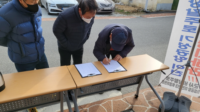 기성면 군사비상활주로 이전 반대투쟁위원회가 군민들을 상대로 이전 반대 서명을 받고 있다. 반대투쟁위 제공