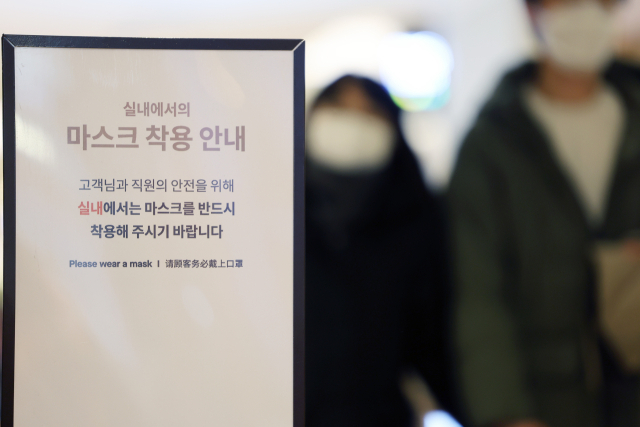 20일 오후 서울의 한 건물에 실내 마스크 착용 안내문이 설치되어 있다. 정부는 실내 마스크 착용 의무를 대중교통, 복지시설, 의료기관을 제외한 시설에 대해 먼저 풀고, 추후 유행 상황을 본 뒤 이들 제외 시설도 해제하는 식의 