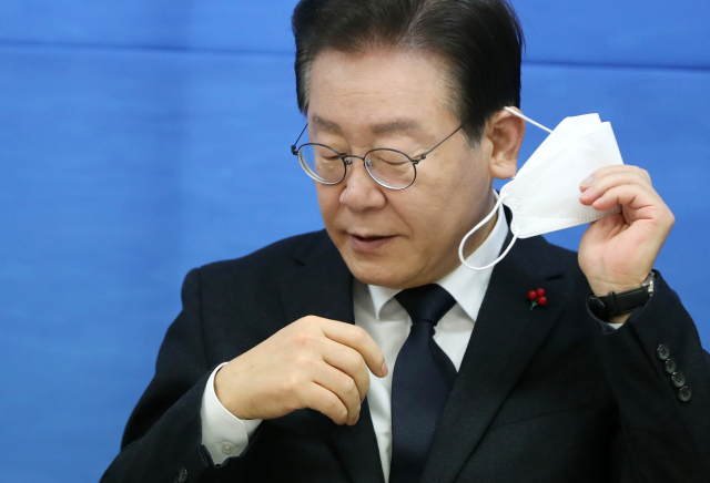 이재명 더불어민주당 대표가 23일 오전 강원 춘천시 강원도당에서 열린 제49차 현장최고위원회의에 참석해 인사말을 하기 전 마스크를 벗고 있다. 연합뉴스
