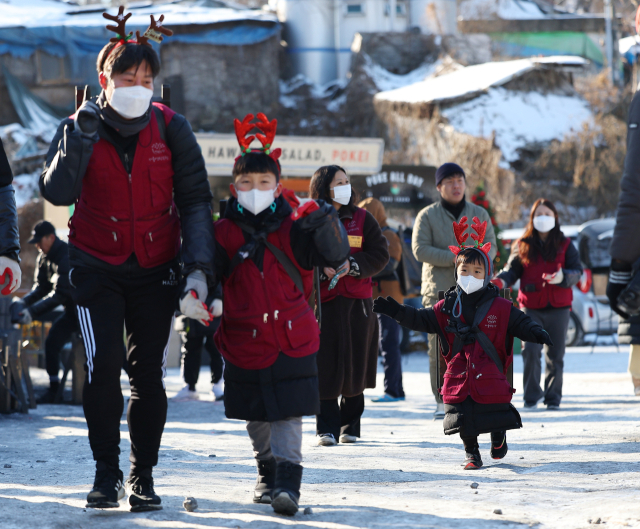 크리스마스이브인 24일 오전 서울 노원구 중계동 백사마을에서 열린 연탄은행 연탄나눔 행사에서 자원봉사자들이 연탄을 옮기고 있다. 연합뉴스