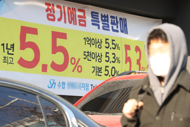 올해 부동산·주식·코인 등 자산 시장 수익률이 크게 떨어진 반면 기준금리와 더불어 예금 금리는 치솟으면서, 역대 가장 많은 시중 자금이 은행 정기예금에 몰린 것으로 나타났다. 사진은 25일 서울 한 은행 앞 내걸린 예금 관련 현수막. 연합뉴스