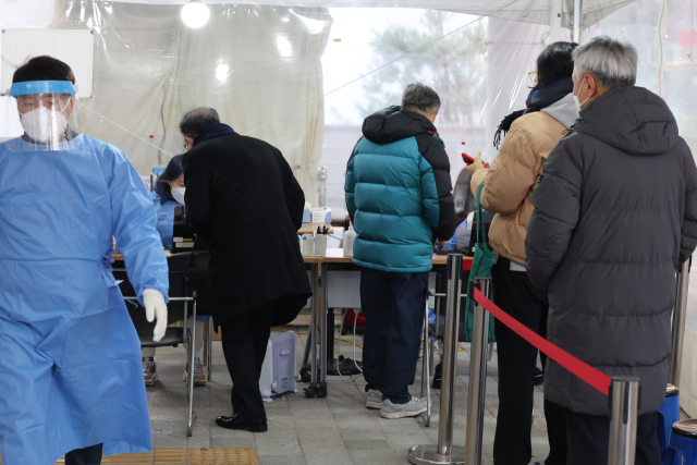 코로나19 겨울 재유행이 이어지는 가운데 26일 오전 서울 마포구보건소 선별검사소에서 시민들이 검사 순서를 기다리고 있다. 연합뉴스