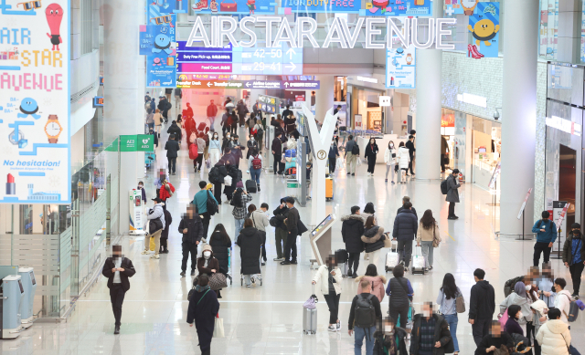22일 오전 인천국제공항 제1여객터미널 면세구역이 연말을 맞아 해외로 여행을 떠나는 탑승객들로 붐비고 있다. 연합뉴스