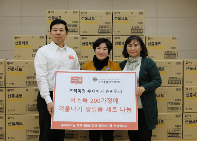 지난 27일 서울시 광진구에 위치한 중곡종합사회복지관에서 진행된 생필품 세트 전달식에서 슈퍼두퍼 강남점 이현우 점장, 더불어민주당 전혜숙 의원, 중곡종합사회복지관 한은경 관장이 사진 촬영을 하고 있다.