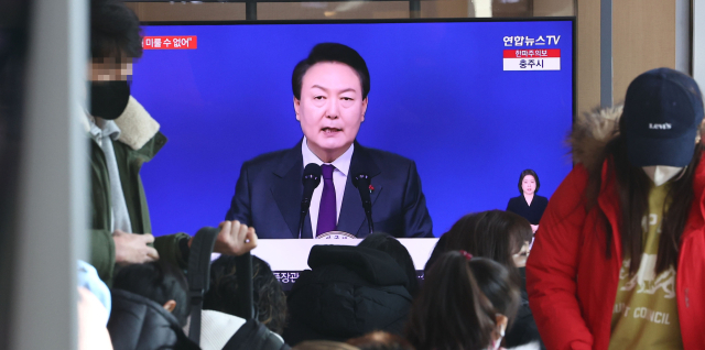 1일 오전 서울역 대합실에서 시민들이 윤석열 대통령의 2023년 신년사 방송을 시청하고 있다. 연합뉴스