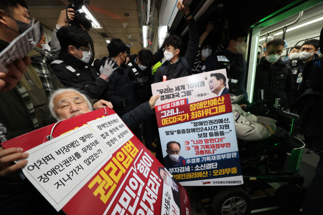 전국장애인차별철폐연대(전장연) 회원들이 13일 오전 서울 용산구 4호선 삼각지역에서 출근길 지하철 탑승 시위를 하고 있다. 서울시는 이날 출근길부터 전장연 시위로 열차 운행이 지연되면 무정차 통과하기로 했으나 이날 삼각지역에 무정차한 열차는 없었다. 연합뉴스