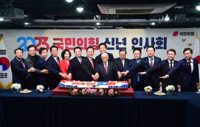 1일 오전 서울 여의도 중앙당사에서 열린 2023 국민의힘 신년인사회에서 주호영 원내대표, 오세훈 서울시장, 목요상, 유흥수, 유준상 상임고문, 당권주자인 김기현, 안철수, 조경태 의원과 당직자들이 떡케이크를 자르고 있다. 연합뉴스