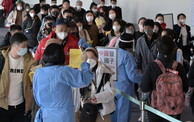 2일 인천국제공항 제1여객터미널 입국장에서 공항 관계자들이 중국발 입국자를 분류하고 있다. 방역당국은 이날부터 중국에서 항공편이나 배편으로 입국하는 모든 사람에 대해 코로나19 유전자증폭(PCR) 검사를 실시하는 등 고강도 방역 대책을 시작했다. 연합뉴스