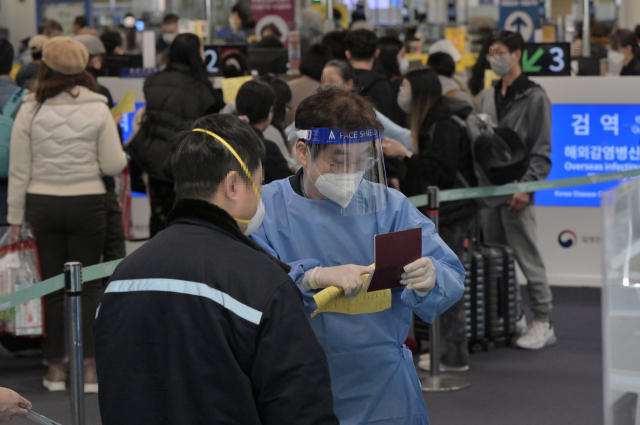 2일 인천국제공항 제1여객터미널 입국장에서 공항 관계자가 중국발 입국자들 중 유증상자를 분리하고 있다. 방역당국은 이날부터 중국에서 항공편이나 배편으로 입국하는 모든 사람에 대해 코로나19 유전자증폭(PCR) 검사를 실시하는 등 고강도 방역 대책을 시작했다. 연합뉴스
