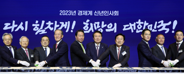 윤석열 대통령이 2일 오후 서울 강남구 코엑스에서 열린 2023 경제계 신년인사회에서 참석자들과 떡을 자르고 있다. 연합뉴스