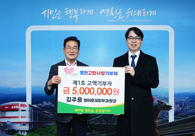 영천시 고향사랑 1호 고액 기부자로 이름을 올린 김주용(오른쪽) 범어로제피부과 원장이 최기문 시장과 기념촬영을 하고 있다. 영천시 제공