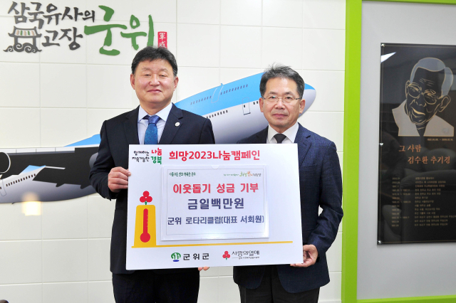 서회원 경북 군위로타리클럽 회장이 이웃돕기 성금을 기탁하고 김진열 군수와 기념 사진을 촬영하고 있다. 군위군 제공