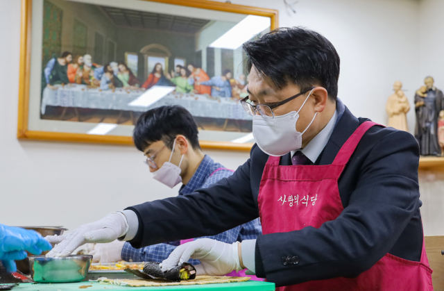 김진욱 고위공직자범죄수사처장이 23일 서울 서초구 까리따스 수녀회 사랑의 식당에서 소외 이웃에 전달할 음식을 준비하고 있다. 연합뉴스