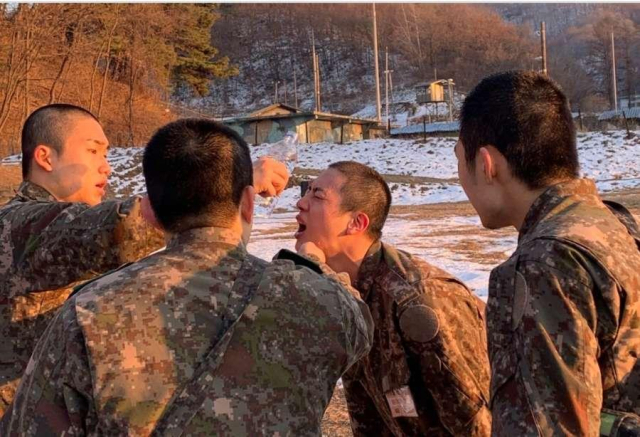 화생방 훈련 후 진의 모습. 고통으로 찌푸려진 진의 얼굴에 동기들이 물을 부어 씻어주는 모습이다. '육군훈련소 대신 전해드립니다' 캡처.