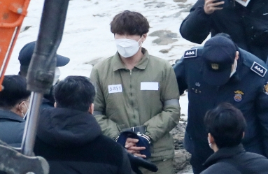 택시 기사와 동거녀를 살해한 혐의로 구속된 이기영이 6일 오후 경기도 파주 공릉천변에서 검찰 관계자들과 현장검증을 하고 있다. 연합뉴스