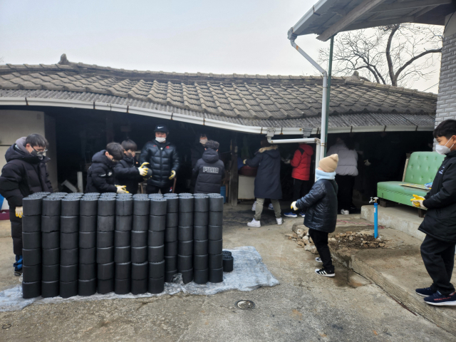 달성 화남태권도 지도진과 원생들이 9일 홀몸 어르신 가정을 찾아 사랑의 연탄나눔 봉사활동을 벌이고 있다. 달성군 제공.