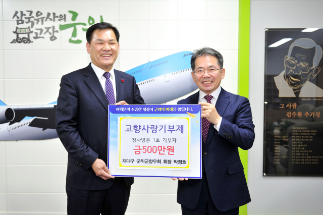 박정호(왼쪽) 재대구 군위군향우회장이 고향사랑기부제 군위군 1호로 500만원을 기부하고, 김진열 군위군수와 기념 사진을 촬영하고 있다. 군위군 제공