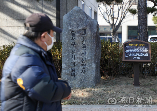 대구시 신청사 사업이 해를 넘겨서도 표류 중이지만, 달서구청은 상권 르네상스 사업 등 올해 신청사 관련 사업을 계획대로 추진할 계획이다. 달서구청 정문 앞 화단에 설치된 신청사 유치 기념비 앞으로 시민이 지나고 있다. 매일신문DB