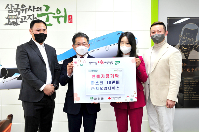 ㈜지오엠티에스 관계자들이 군위군에 마스크를 기탁하고, 김진열 군수와 기념 사진을 촬영하고 있다. 군위군 제공