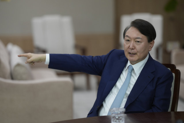 윤석열 대통령이 지난 10일 서울 용산 대통령실 청사에서 AP통신과 인터뷰를 하는 도중 집무실 책상위에 놓인 흰색 전화기(북한 직통 핫라인)를 가리키고 있다. 윤 대통령은 