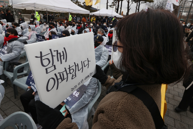 14일 오후 서울 용산구 전쟁기념관 앞에서 열린 10.29 이태원 참사 유가족협의회·10.29 이태원 참사 시민대책회의 주최 3차 시민추모제에서 한 참석자가 손팻말을 들고 있다. 연합뉴스