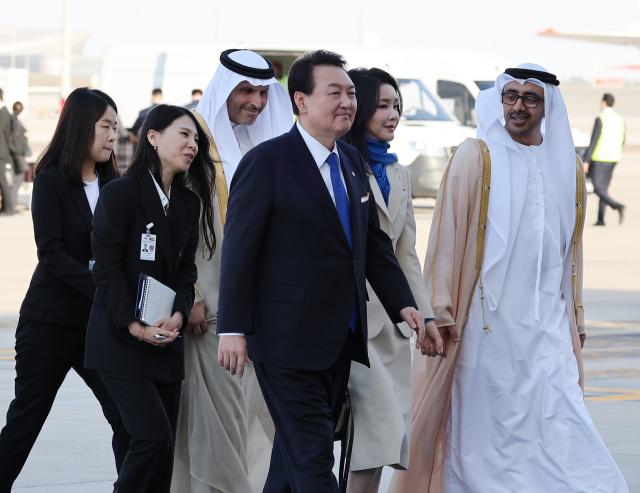 윤석열 대통령과 김건희 여사가 14일(현지시간) 아랍에미리트(UAE) 아부다비 왕실공항에 도착, 공군 1호기에서 내려 영접인사와 이동하고 있다. 연합뉴스