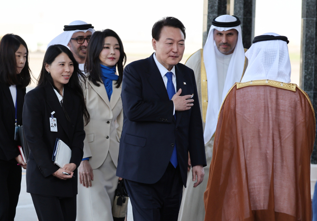 윤석열 대통령과 김건희 여사가 14일(현지시간) 아랍에미리트(UAE) 아부다비 왕실공항에 도착, 공군 1호기에서 내려 영접인사를 만나고 있다. 연합뉴스