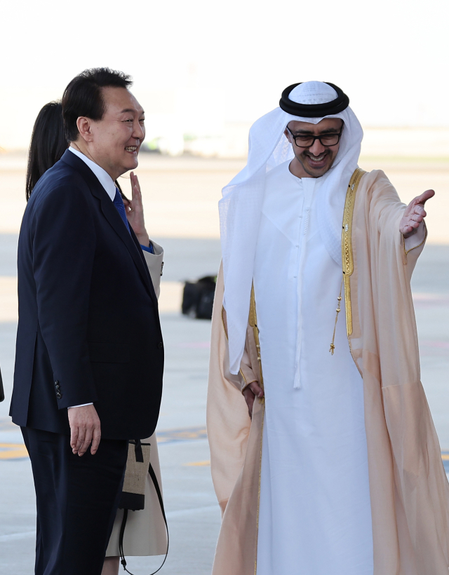 윤석열 대통령과 김건희 여사가 14일(현지시간) 아랍에미리트(UAE) 아부다비 왕실공항에 도착, 공군 1호기에서 내려 영접인사를 만나 대화하고 있다. 연합뉴스