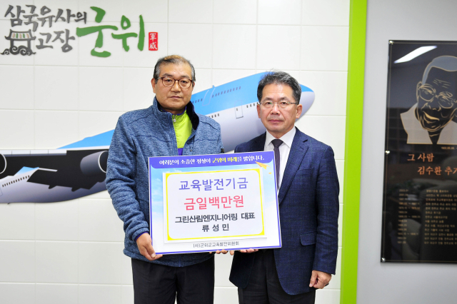 류성민(왼쪽) 그린산림엔지니어링 대표가 군위군에 교육발전기금을 기탁하고 김진열(오른쪽) 군위군수와 기념 사진을 촬영하고 있다. 군위군 제공
