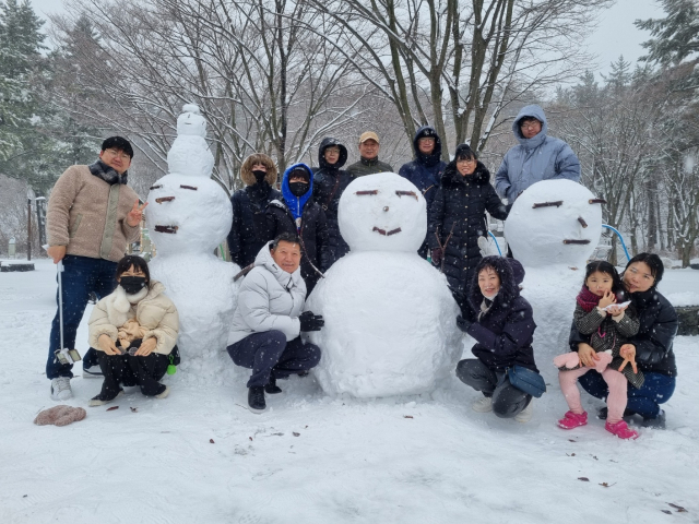 울릉크루즈 후원으로 바다여행을 떠난 봉화 매몰광산 생환 광부 박정하 씨 가족이 15일 눈 내리는 울릉도 나리분지에서 건강과 행복을 비는 소망눈사람을 만들었다. 울릉크루즈 제공