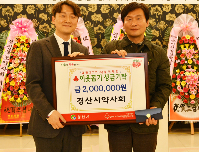 김진택(왼쪽) 경산시약사회 회장은 최근 열린 정기총회에서 회원들이 모은 이웃돕기 성금 200만원을 경산시에 기탁했다.
