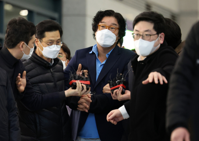 해외 도피 중 태국에서 붙잡힌 김성태 쌍방울 그룹 전 회장이 17일 인천공항을 통해 귀국하고 있다. 특정경제범죄가중처벌법상 횡령 혐의로 수사를 받던 김 전 회장은 지난해 5월 말 검찰의 압수수색을 앞두고 싱가포르로 출국한 뒤 태국으로 거처를 옮겨 8개월 가까이 도피했다. 연합뉴스