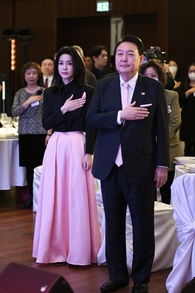 스위스를 방문 중인 윤석열 대통령과 김건희 여사가 17일(현지시간) 취리히 시내 한 호텔에서 열린 스위스 동포 초청 만찬 간담회에서 국기에 경례하고 있다. 연합뉴스